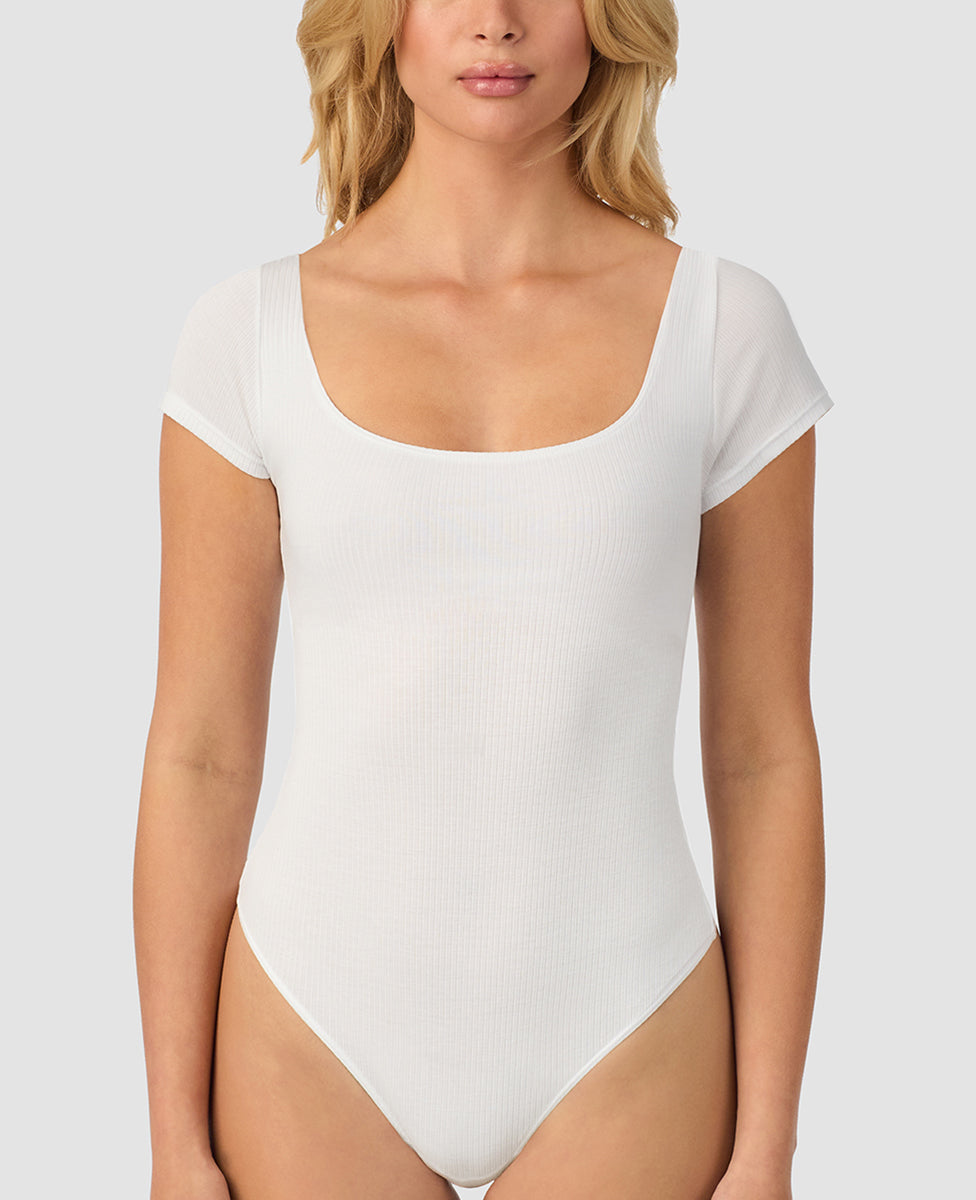 A lady wearing white Cabana Cotton Rib Bodysuit