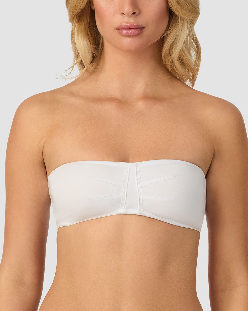 A lady wearing white cabana cotton bandeau bralette.