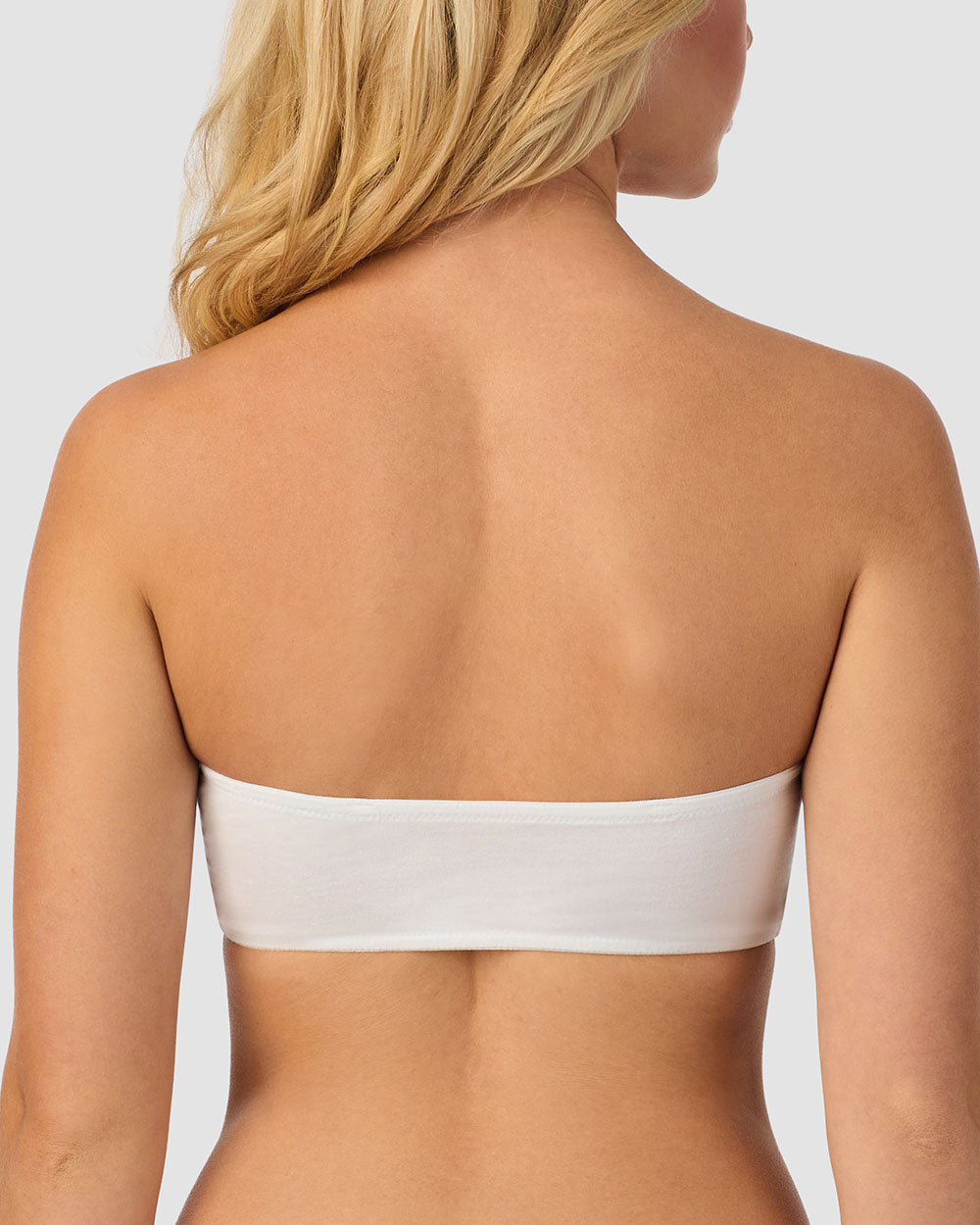 A lady wearing white cabana cotton bandeau bralette.