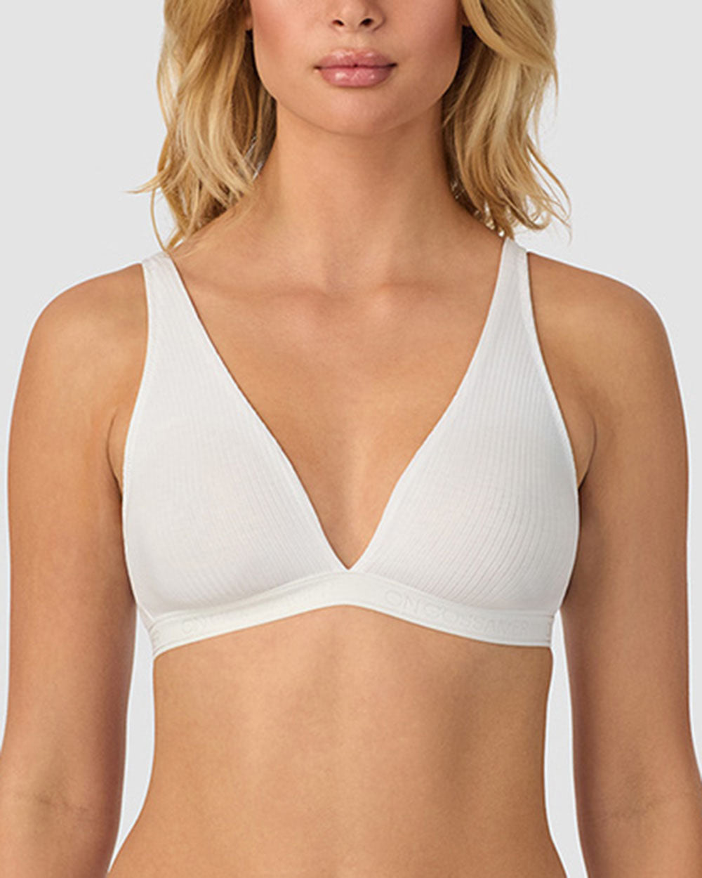 A lady wearing white Cabana Cotton Rib Plunge Bralette